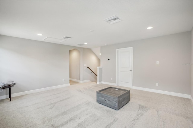 basement with baseboards, visible vents, arched walkways, and recessed lighting