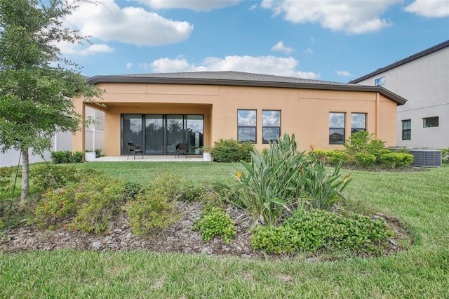 back of house with a patio, a lawn, and stucco siding