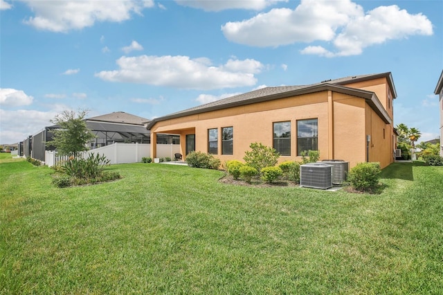 back of house with a yard, cooling unit, fence, and stucco siding