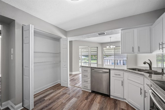 kitchen with visible vents, a sink, stainless steel appliances, white cabinetry, and dark wood-style flooring