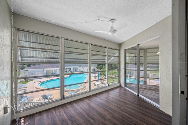 unfurnished sunroom with ceiling fan