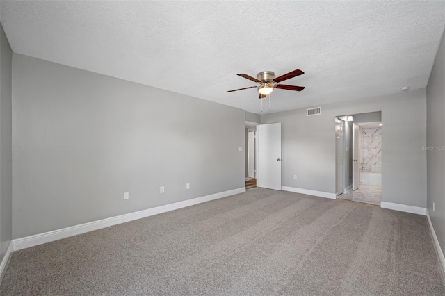 unfurnished bedroom featuring visible vents, a textured ceiling, ensuite bath, carpet flooring, and baseboards