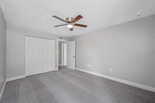 unfurnished bedroom with a closet, baseboards, carpet, and a textured ceiling