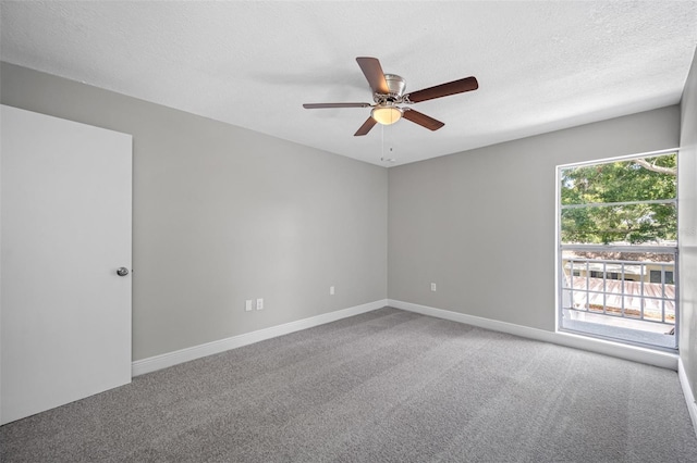 empty room with carpet flooring, a ceiling fan, baseboards, and a textured ceiling