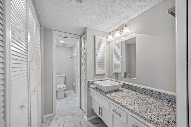 bathroom with toilet, vanity, a closet, marble finish floor, and a textured ceiling