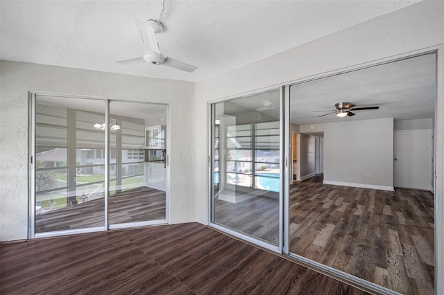 unfurnished sunroom with ceiling fan with notable chandelier