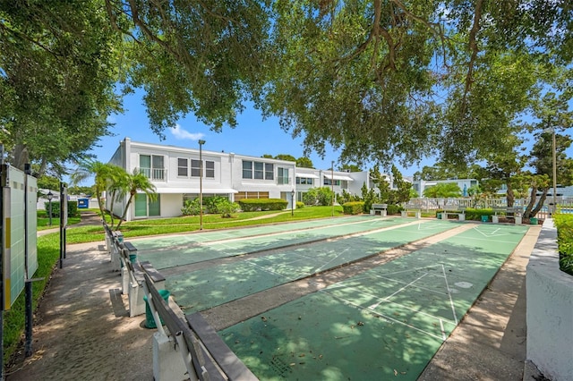 view of home's community with a lawn and shuffleboard