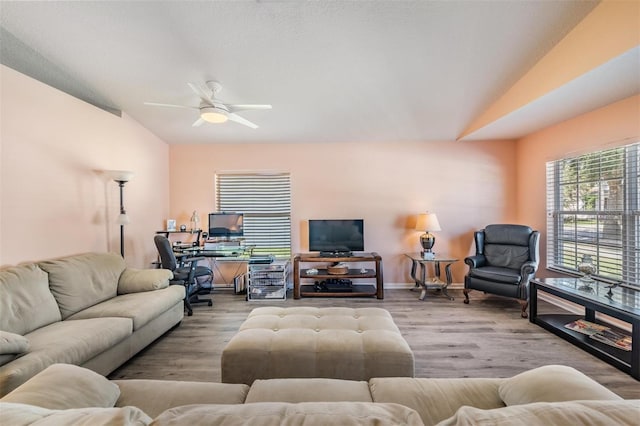 living room with lofted ceiling, ceiling fan, and light wood-type flooring