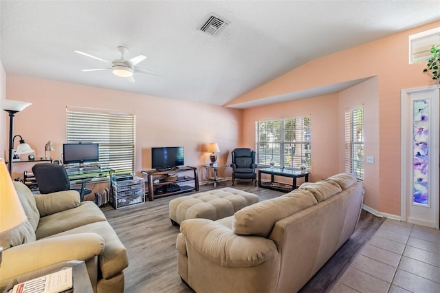 living room with lofted ceiling, wood finished floors, a ceiling fan, visible vents, and baseboards