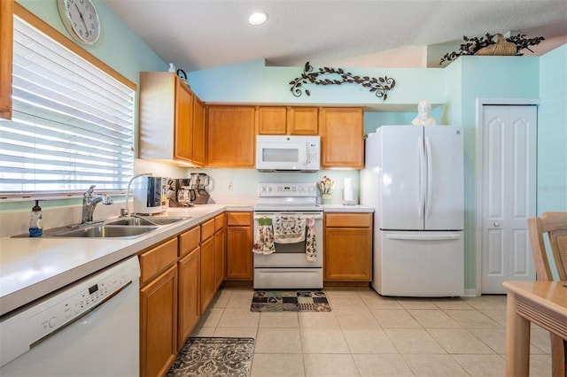 kitchen with light tile patterned floors, white appliances, a sink, vaulted ceiling, and light countertops