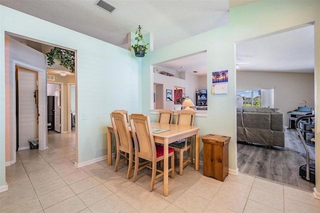 dining area with light hardwood / wood-style flooring and vaulted ceiling