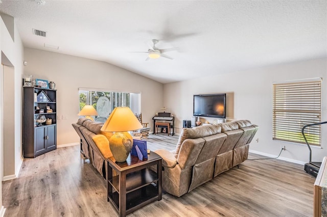 living area with vaulted ceiling, ceiling fan, visible vents, and light wood-style floors