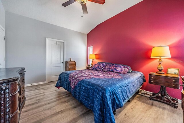 bedroom featuring ceiling fan, vaulted ceiling, baseboards, and wood finished floors