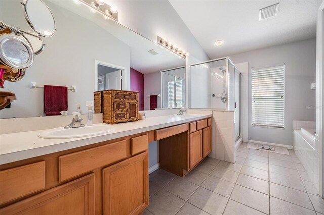 bathroom featuring vaulted ceiling, separate shower and tub, vanity, and tile patterned floors