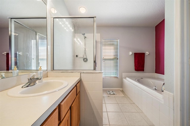 bathroom featuring a textured ceiling, vanity, tile patterned floors, and shower with separate bathtub