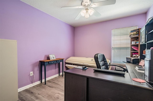 office space with a ceiling fan, baseboards, and light wood finished floors