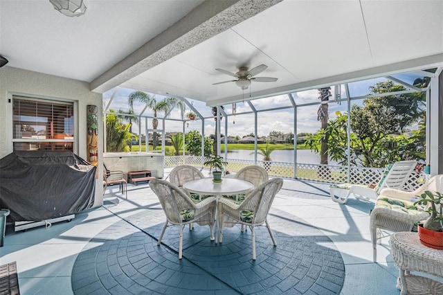 sunroom / solarium featuring ceiling fan and a water view