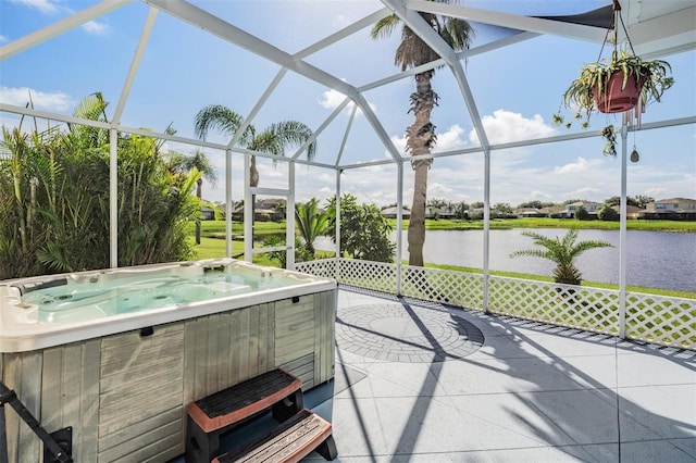 view of patio / terrace with glass enclosure, a water view, and a hot tub