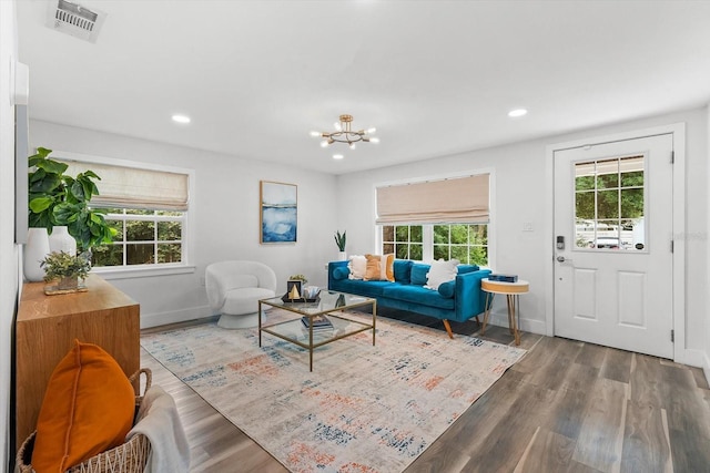 living room with wood-type flooring and an inviting chandelier