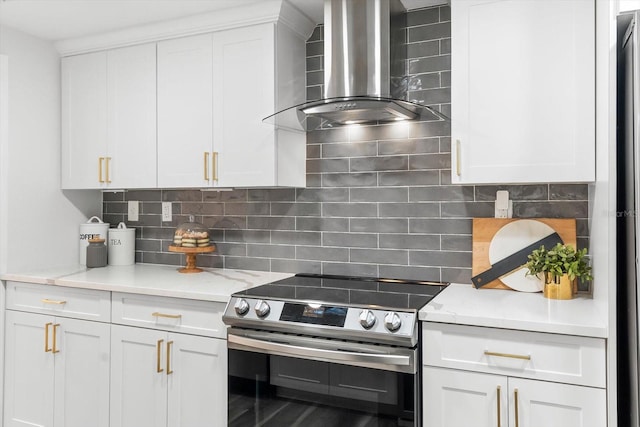 kitchen featuring wall chimney range hood, white cabinets, backsplash, and electric stove