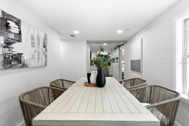 dining room with plenty of natural light and a barn door