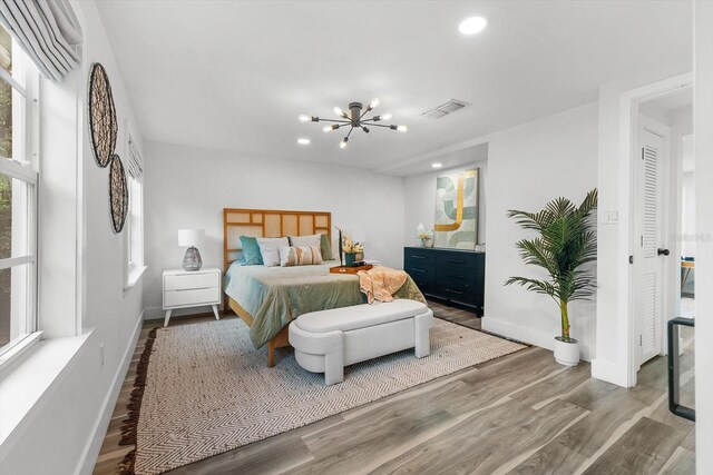 bedroom featuring hardwood / wood-style flooring and a chandelier