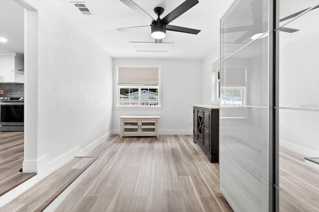 interior space with stainless steel range with electric cooktop, plenty of natural light, light hardwood / wood-style floors, and tasteful backsplash