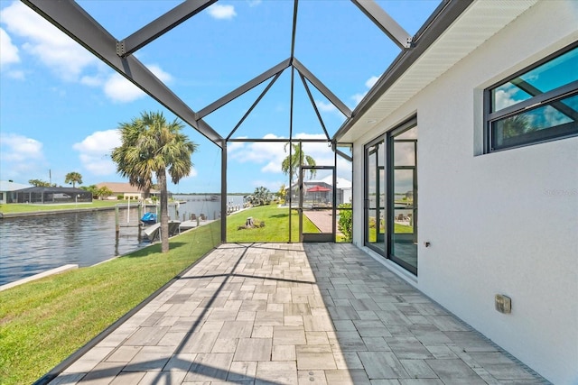 view of patio featuring a lanai, a water view, and a boat dock