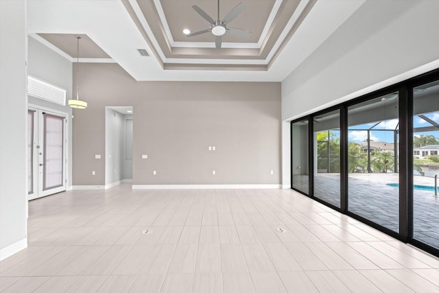 tiled spare room featuring ceiling fan, french doors, crown molding, a towering ceiling, and a tray ceiling