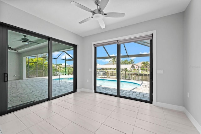 tiled spare room featuring a wealth of natural light, ceiling fan, and a water view