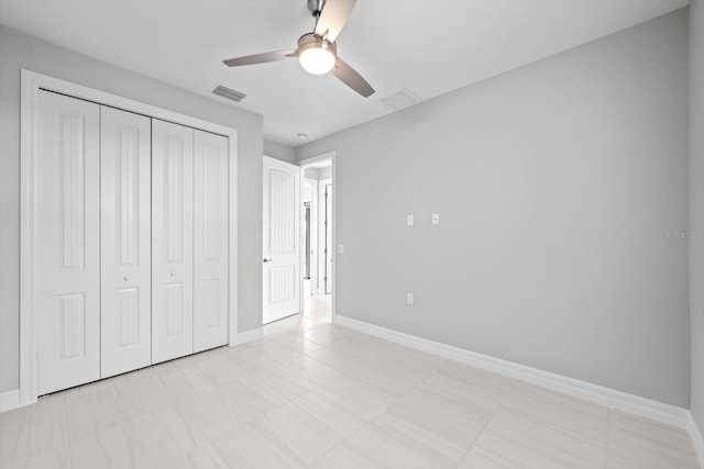 unfurnished bedroom featuring ceiling fan and a closet