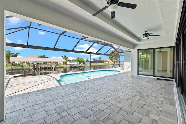 view of swimming pool featuring glass enclosure, ceiling fan, a water view, and a patio