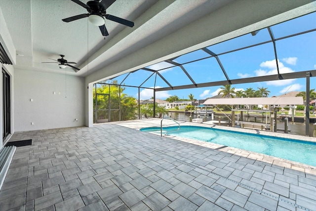 view of swimming pool featuring ceiling fan, a lanai, a patio, and a water view