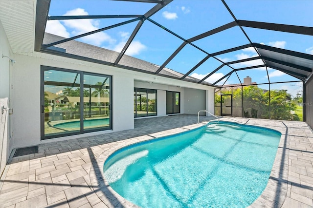 view of swimming pool with glass enclosure and a patio