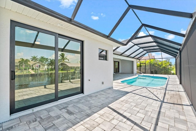 view of swimming pool with a water view, glass enclosure, and a patio area