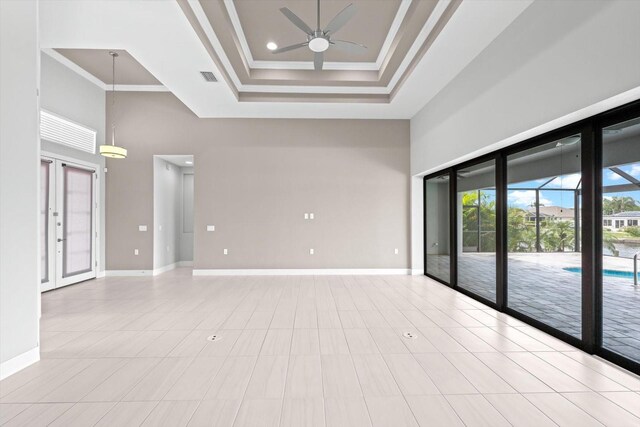 5217 Forbes Ter, Port Charlotte, FL 33981 - unfurnished room with a towering ceiling, a ceiling fan, baseboards, a tray ceiling, and french doors