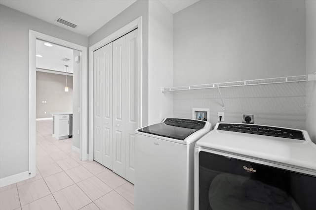 5217 Forbes Ter, Port Charlotte, FL 33981 - laundry room featuring washing machine and clothes dryer, light tile patterned floors, and baseboards