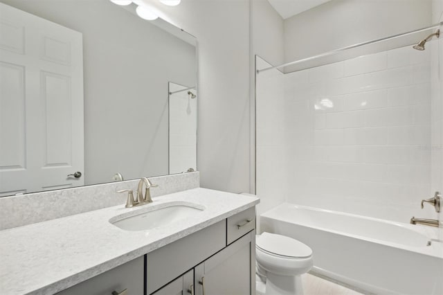 full bathroom featuring vanity, tiled shower / bath combo, and toilet