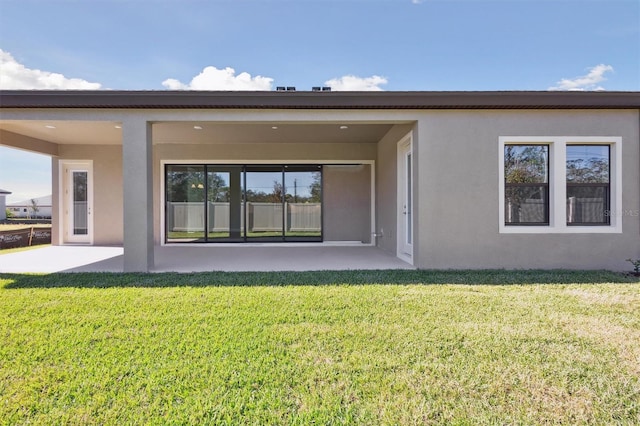 rear view of property with a lawn and a patio