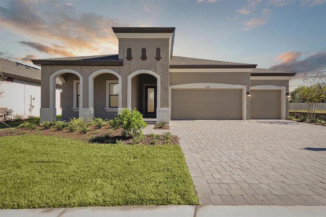 mediterranean / spanish-style home featuring a garage and a yard