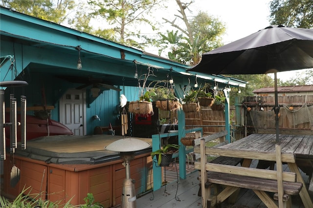 view of patio with a hot tub and a deck