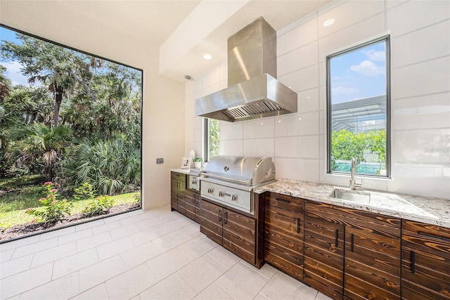 kitchen with sink, light stone countertops, and island exhaust hood