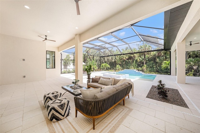 view of patio featuring an outdoor living space, ceiling fan, and glass enclosure