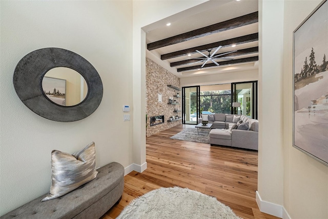 living room featuring hardwood / wood-style flooring, a fireplace, and beam ceiling