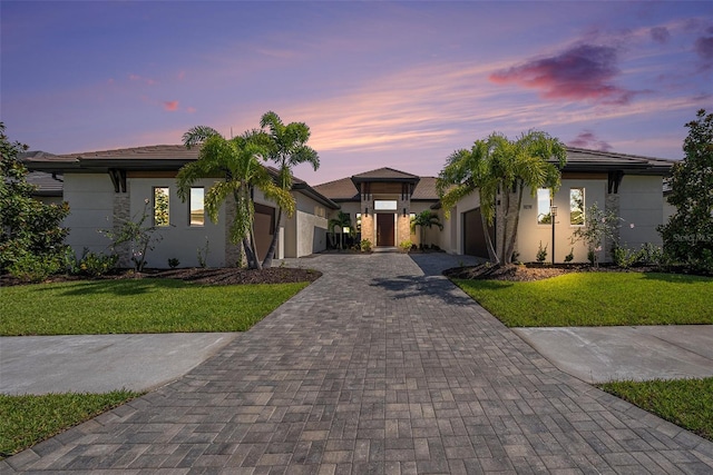 view of front of house with a garage and a lawn