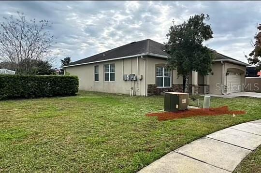 view of property exterior with a lawn, a garage, and cooling unit