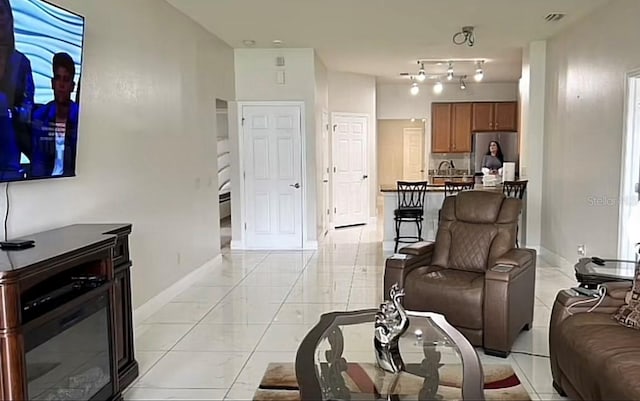 living room with rail lighting and light tile patterned floors