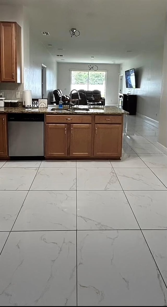 kitchen with sink, kitchen peninsula, stainless steel dishwasher, and light tile patterned floors