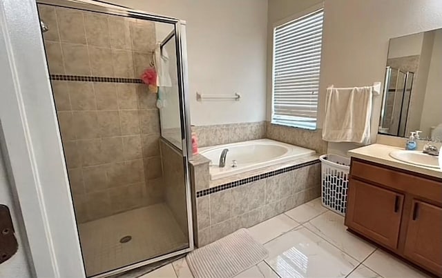 bathroom featuring tile patterned flooring, shower with separate bathtub, and vanity