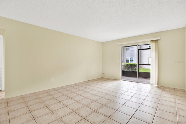 spare room with a textured ceiling and light tile patterned floors